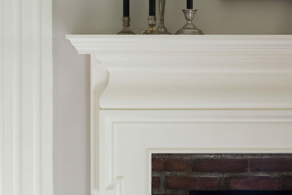 Complementary white trim glosses on a fireplace