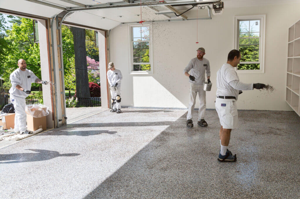 applying second coat of epoxy to garage floor