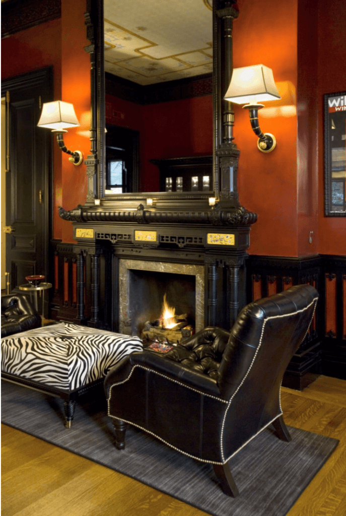 3. view of living room and fireplace with elephant sconces in historic home